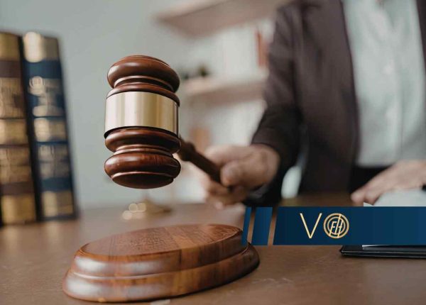 Młotek sędziowski uderzający w podstawkę na biurku w sądzie