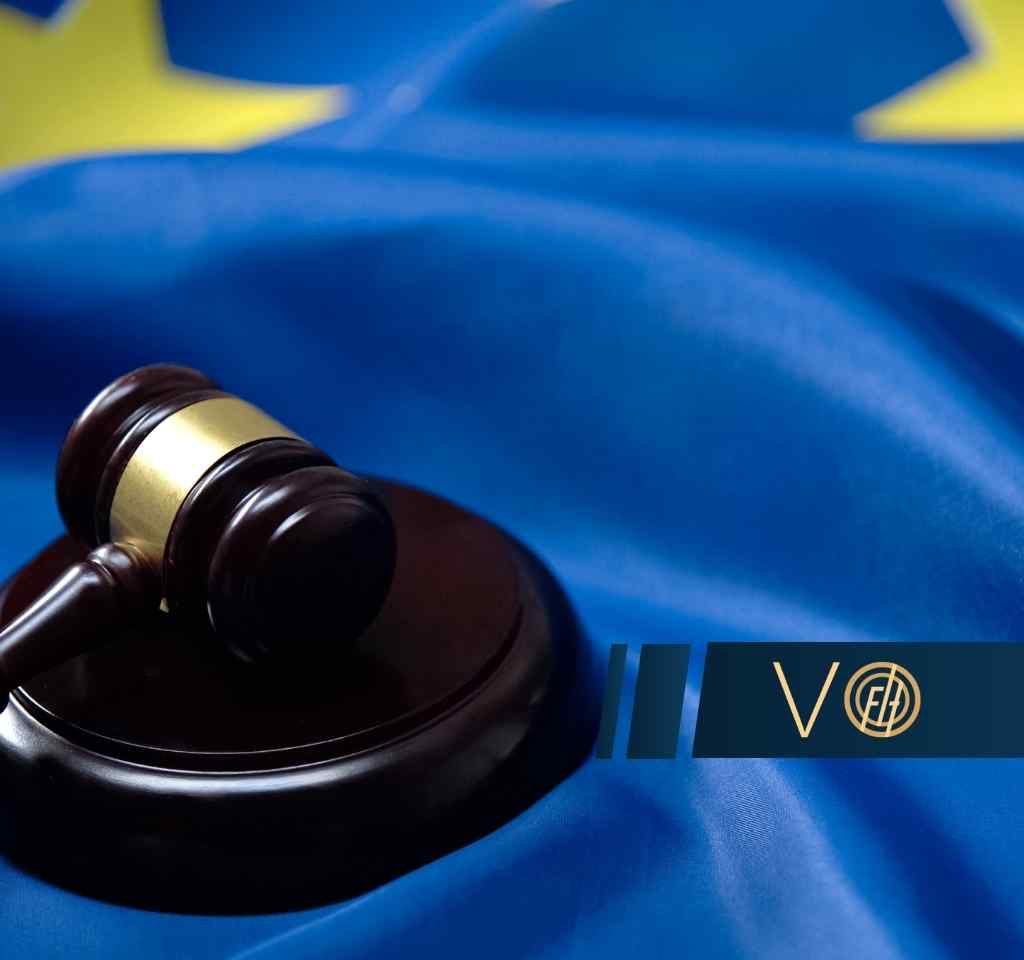 Drewniany młotek sędziowski leży na fladze Unii Europejskiej