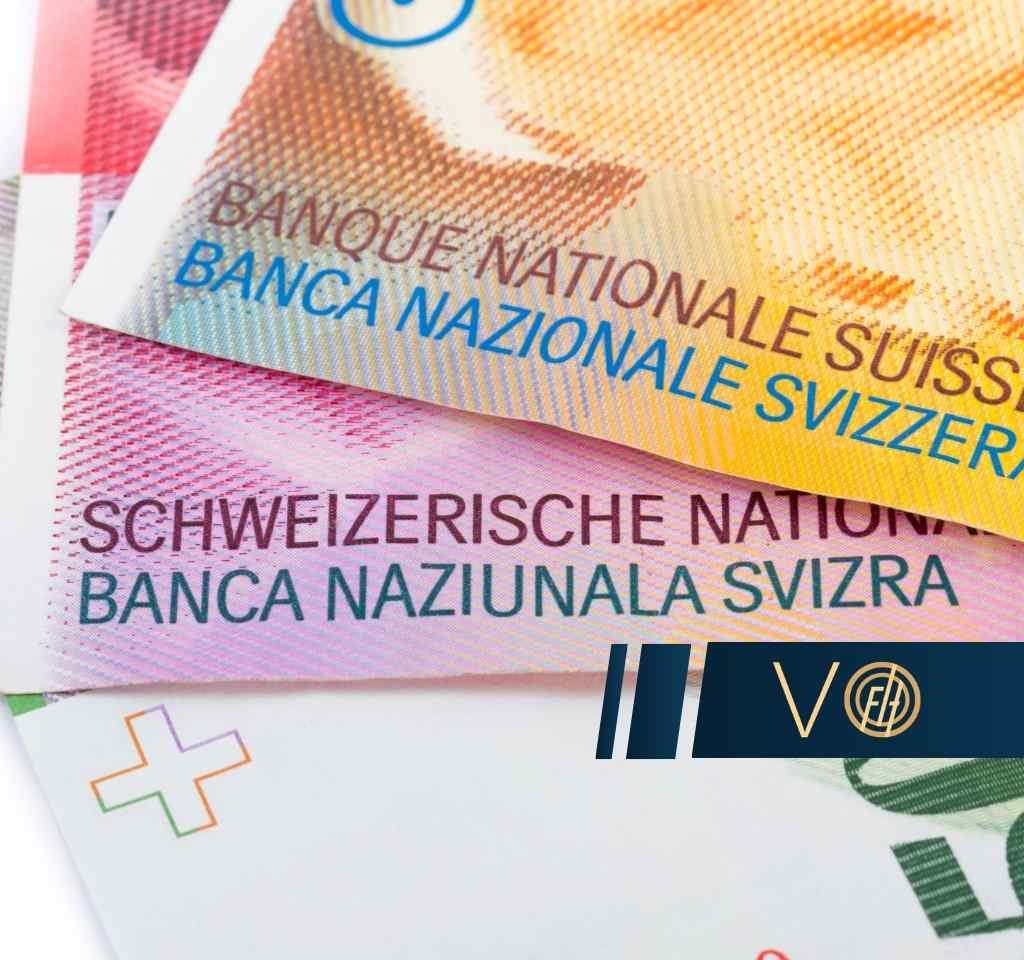 Zbliżenie na fragmenty banknotów franków szwajcarskich z widocznymi napisami "Banque Nationale Suisse" oraz "Schweizerische Nationalbank".
