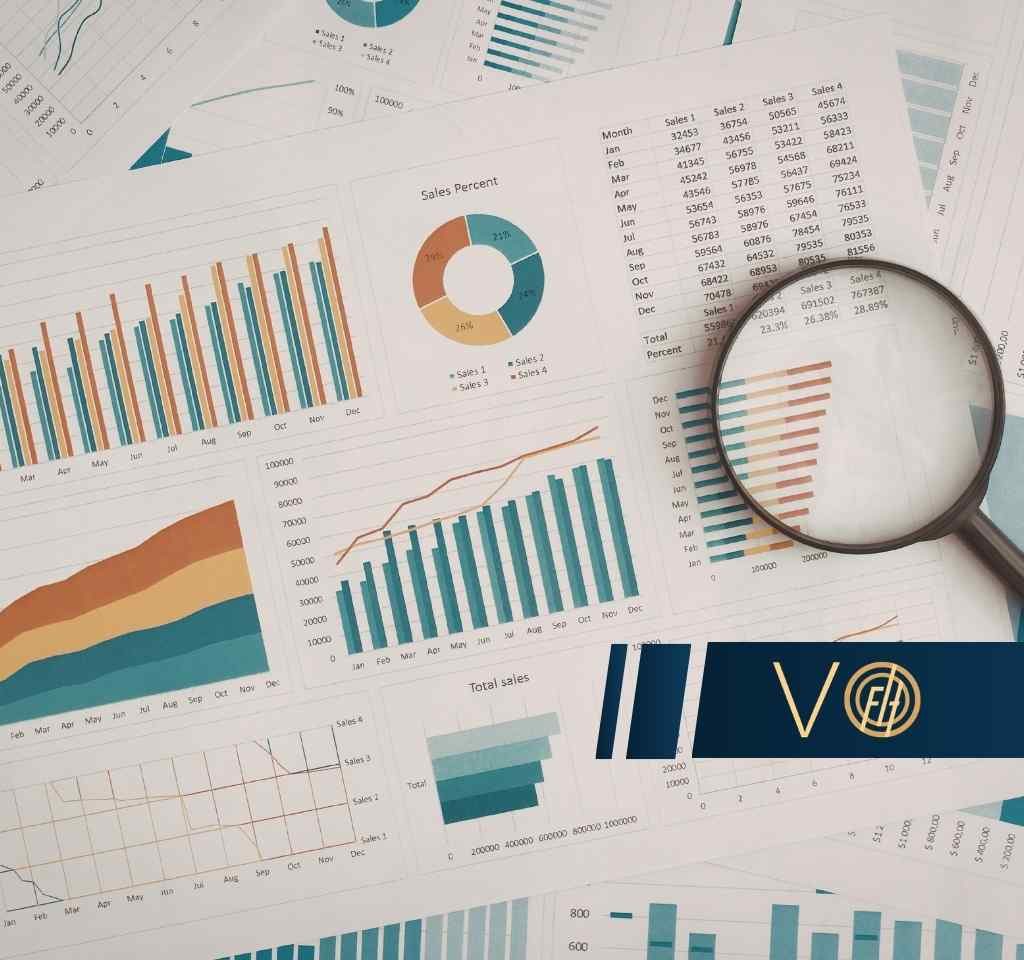 Różnorodne wykresy biznesowe, tabele z danymi finansowymi oraz lupa leżąca na dokumentach, symbolizujące szczegółową analizę procesową.