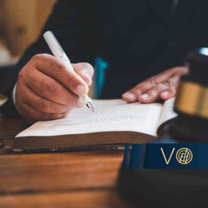 Prawnik analizujący przepisy w księdze obok młotka sędziowskiego