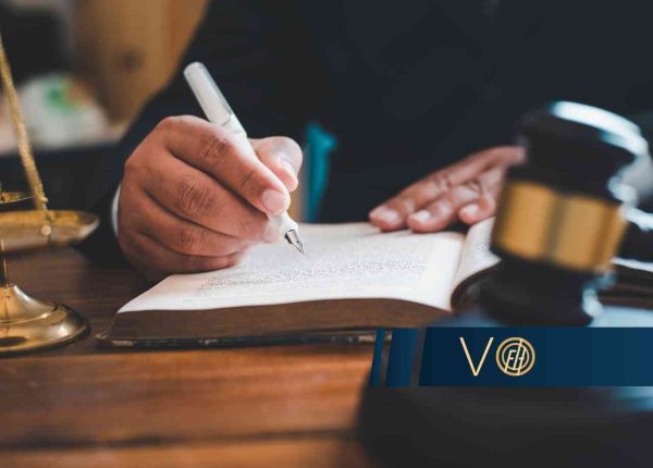 Prawnik analizujący przepisy w księdze obok młotka sędziowskiego