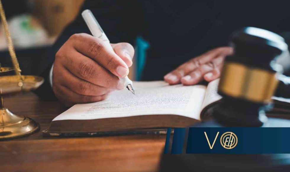 Prawnik analizujący przepisy w księdze obok młotka sędziowskiego