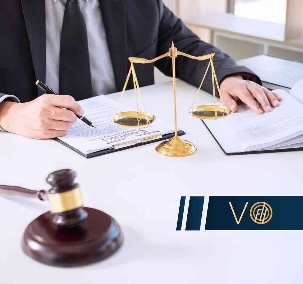 Prawnik podpisujący umowę na tle złotej wagi szalowej i otwartej księgi, z młotkiem sędziowskim na pierwszym planie