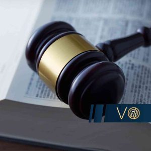 Młotek sędziowski leżący na otwartej księdze z tekstami prawnymi