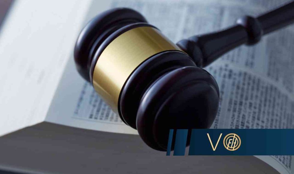 Młotek sędziowski leżący na otwartej księdze z tekstami prawnymi