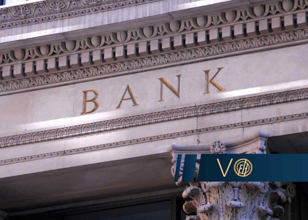 Close-up of a historic bank façade with ornamental carvings and the word BANK in gold letters.