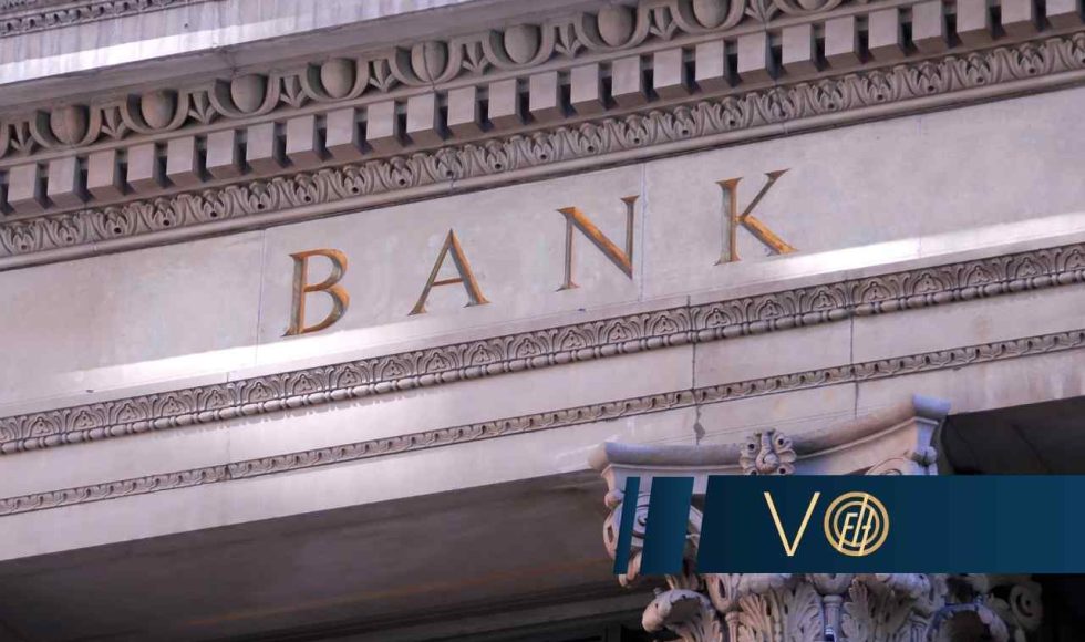 Close-up of a historic bank façade with ornamental carvings and the word BANK in gold letters.