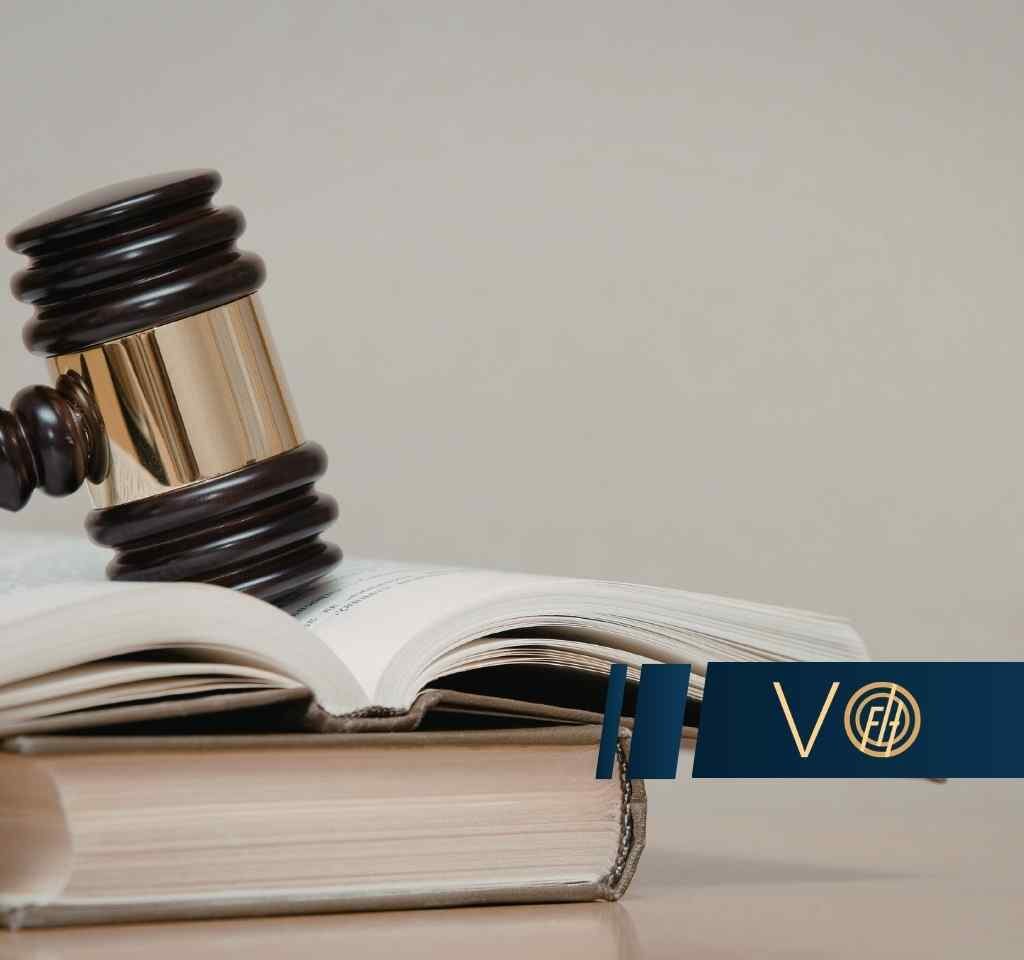 Gavel resting on an open law book with a blue VO banner in the foreground.