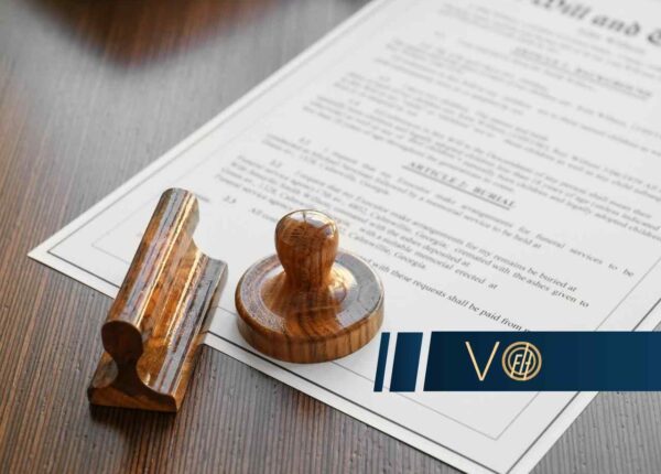 Formal legal document with a wooden stamp and seal on a wooden surface, a blue logo overlay in the corner.