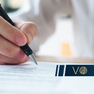Close-up of a hand signing a document with a pen, a blue logo banner across the bottom.