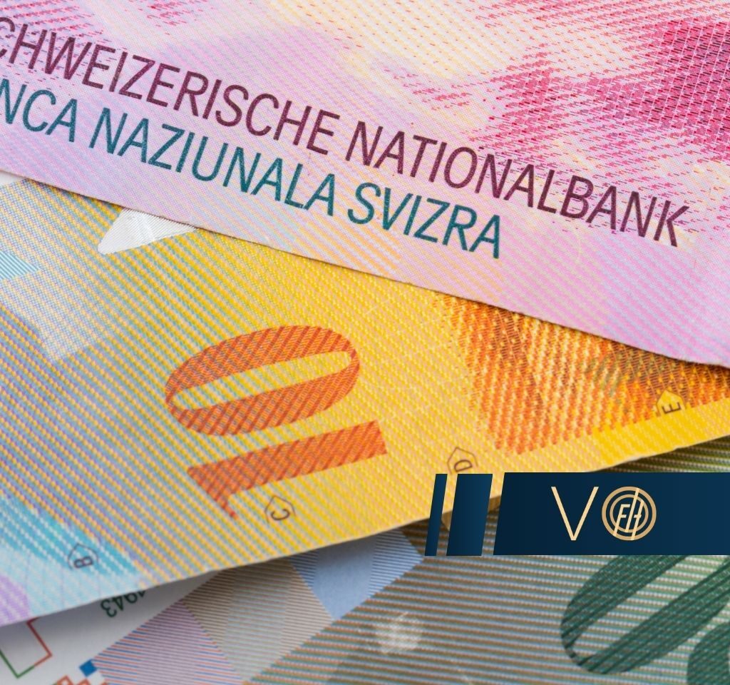 Close-up of overlapping colorful Swiss banknotes with a dark blue VO banner across them, emphasizing money and branding.
